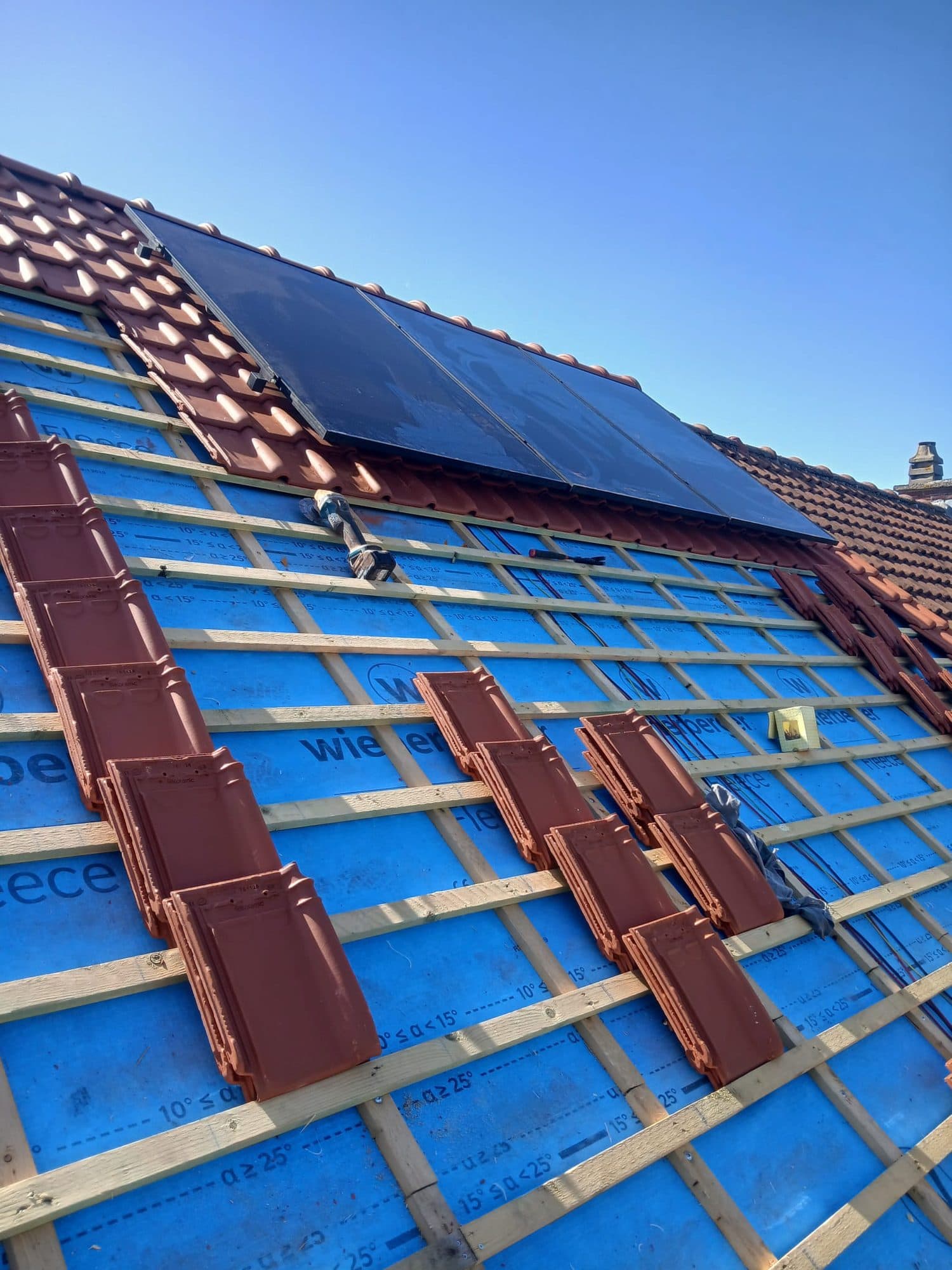 Dakpannen en zonnepanelen tijdens de plaatsing in Londerzeel