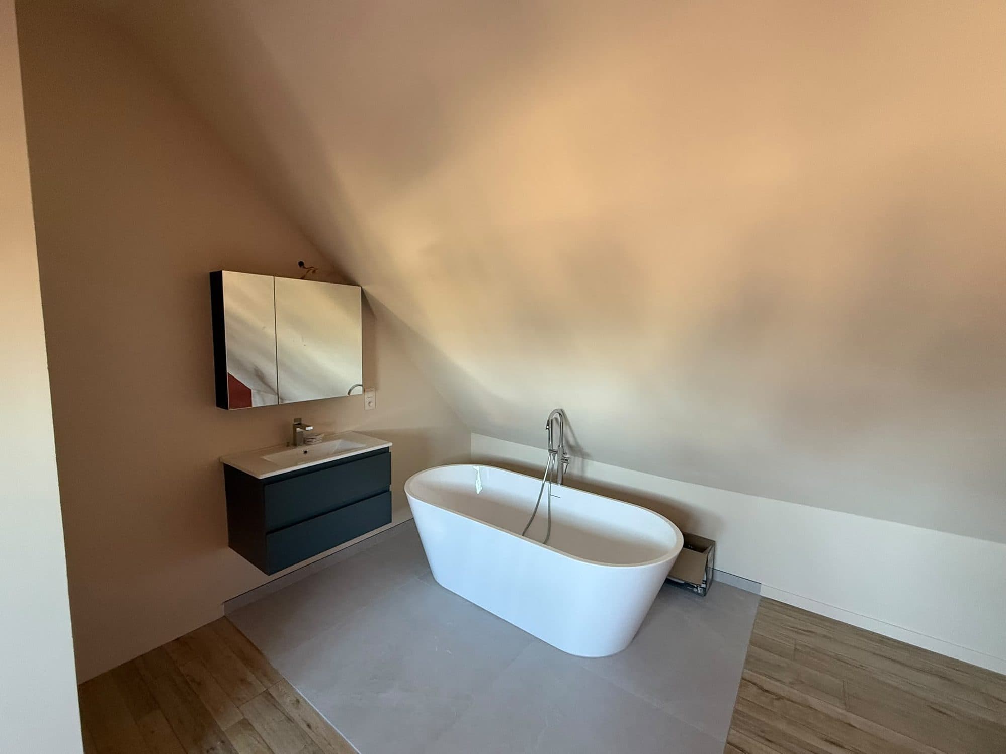 En-suite badkamer op zolder in Zwijnaarde met vrijstaand bad en badkamermeubel
